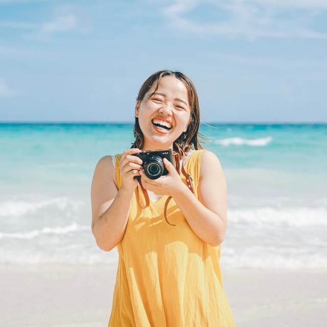 宮古島での撮影を担当するカメラマンひかりん - ビーチでカメラを手に笑顔