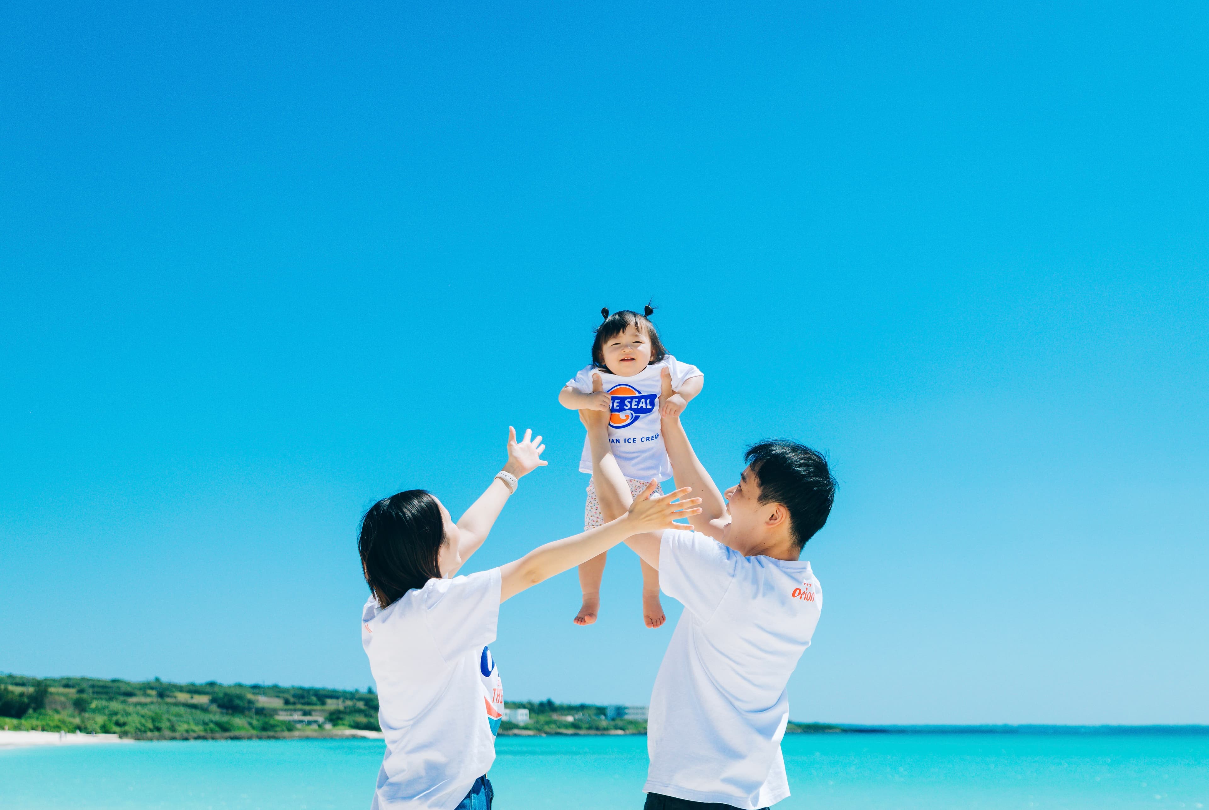 宮古島での家族写真撮影:ビーチで子供を高く抱き上げる親子